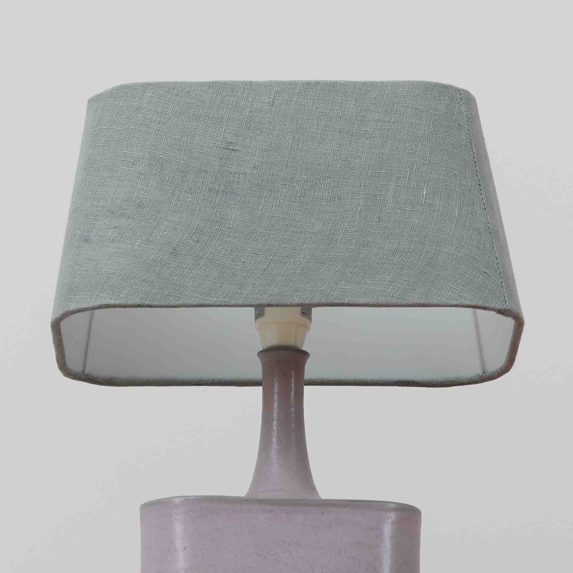 こちらのテーブルランプは、陶磁器ベースに淡いパープルやブルーを溶け合わせたような独特の釉薬表情が魅力で、ビンテージならではの柔らかなグラデーションが優しい存在感を放つ一品です。細く立ち上がる支柱にリネンシェードを組み合わせたシンプルな構造は安定感があり、点灯時にはシェード越しに温かく穏やかな光が広がります。高さ46cmと扱いやすいサイズで、ベッドサイドやリビングのサイドテーブルにも取り入れやすく、北欧らしい静かな色彩と経年の味わいを楽しめるビンテージ照明です。