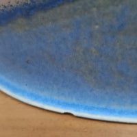 こちらのテーブルランプは、陶磁器ベースに淡いパープルやブルーを溶け合わせたような独特の釉薬表情が魅力で、ビンテージならではの柔らかなグラデーションが優しい存在感を放つ一品です。細く立ち上がる支柱にリネンシェードを組み合わせたシンプルな構造は安定感があり、点灯時にはシェード越しに温かく穏やかな光が広がります。高さ46cmと扱いやすいサイズで、ベッドサイドやリビングのサイドテーブルにも取り入れやすく、北欧らしい静かな色彩と経年の味わいを楽しめるビンテージ照明です。