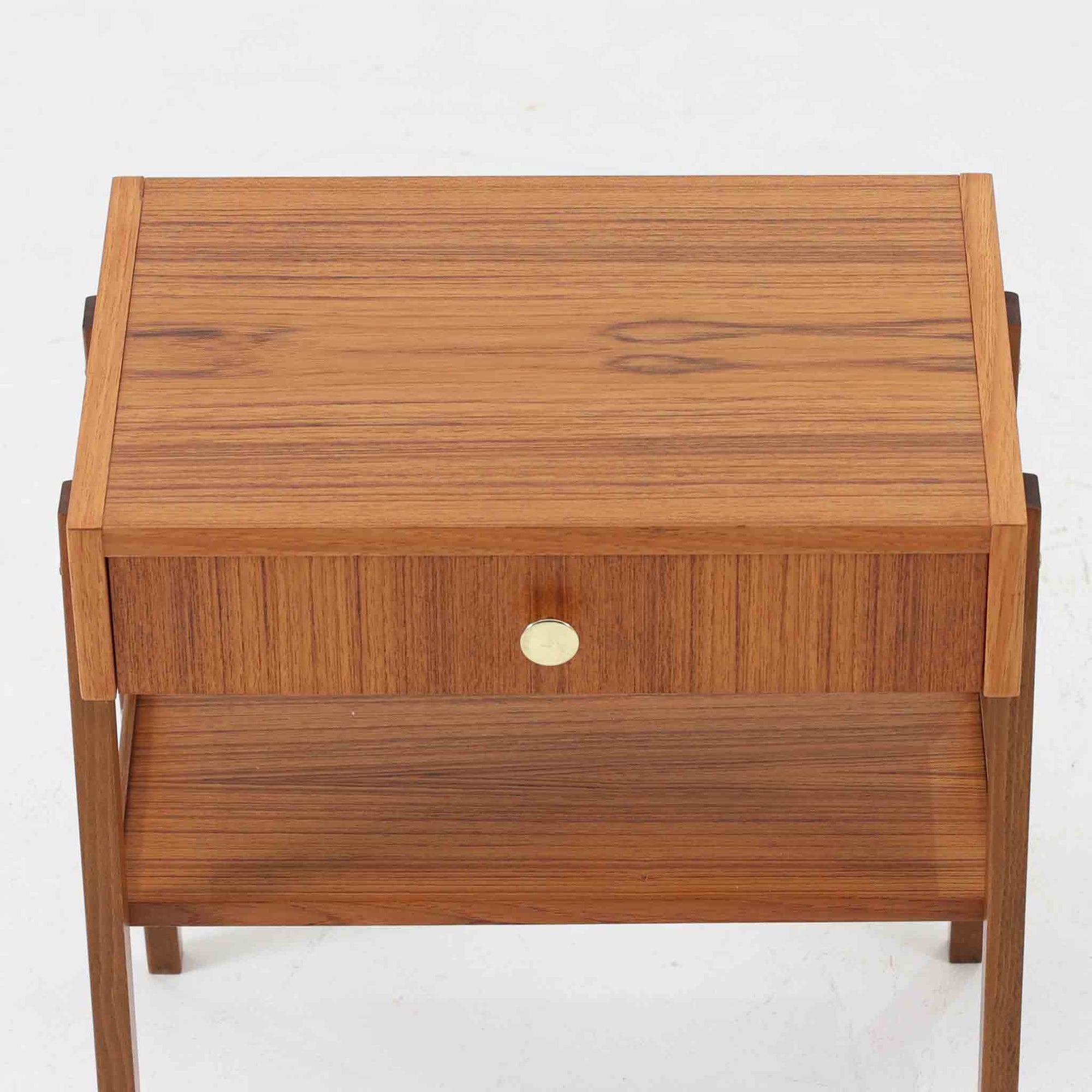 スウェーデン製のこちらのサイドチェストは、チーク材の美しい木目とビーチ材の脚部を組み合わせた軽やかな構成が魅力で、前板にあしらわれたゴールド色のメタルの取手が上品なアクセントを添える北欧ビンテージ品です。引き出しに加えて下段にはオープンシェルフが設けられ、ベッドサイドやリビングのサイドテーブルとして実用性高くお使いいただけます。細身のフレームでありながらしっかりとした造りで、経年により深まった木肌の風合いが空間に温かさと落ち着きをもたらす一台です。