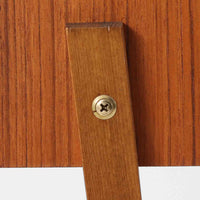 スウェーデン製のこちらのサイドチェストは、チーク材の美しい木目とビーチ材の脚部を組み合わせた軽やかな構成が魅力で、前板にあしらわれたゴールド色のメタルの取手が上品なアクセントを添える北欧ビンテージ品です。引き出しに加えて下段にはオープンシェルフが設けられ、ベッドサイドやリビングのサイドテーブルとして実用性高くお使いいただけます。細身のフレームでありながらしっかりとした造りで、経年により深まった木肌の風合いが空間に温かさと落ち着きをもたらす一台です。