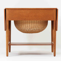 ハンス・J・ウェグナーが手がけ、Andreas Tuck社より製作されたAT33ソーイングテーブルは、天板を広げられる独創的な構造と実用性を兼ね備えた北欧ビンテージを代表する一台です。中央には引き出しと仕切り付き収納、下部にはラタンバスケットを備え、道具をすっきりと収められる設計が魅力。AT33は複数の素材構成で展開されたモデルですが、こちらは天板にチーク突板材、脚部にオーク無垢材を用いた仕様で、素材のコントラストと軽やかな佇まいが特徴です。異素材を巧みに組み合わせた構造と端正なプロポーションは、使うほどに職人技と経年変化の美しさを実感できます。