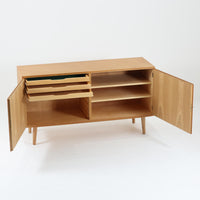 Poul Hundevadが手がけ、Hundevad & Coより製作されたキャビネットです。オーク材の端正な木目を活かしたフラットな扉構成と、細身のテーパードレッグが北欧モダンらしい軽やかさを演出します。内部は可動棚と可動式の浅型トレイを備え、書類や食器、小物まで用途に応じた整理が可能。天板下の構造や金物の収まりにも丁寧な作りが感じられ、長年の使用で深みを増した素材感がビンテージならではの魅力として空間に静かな存在感を添えます。