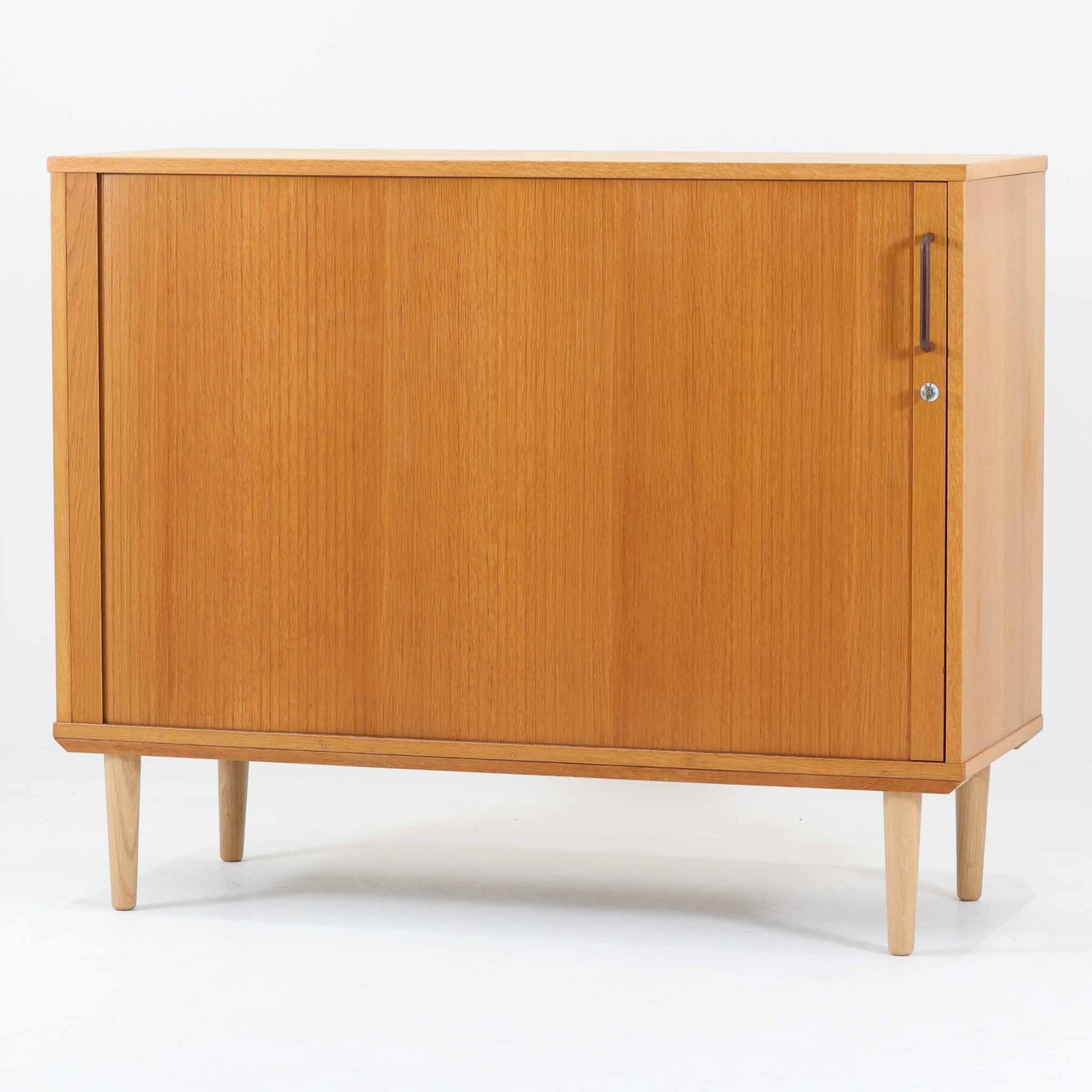 デンマーク製のボードです。温かみのあるオーク材を使用し、滑らかに開閉する蛇腹扉が特徴的な一台。内部は可動棚付きで収納力があり、食器や書類、日用品などをすっきりと収められます。丸みを帯びた脚部が軽やかな印象を与え、幅116cmの程よいサイズ感はリビングやダイニング、書斎にも取り入れやすい設計です。経年により深みを増した木目と丁寧なつくりから、北欧ビンテージならではの質実剛健な魅力が感じられる逸品です。