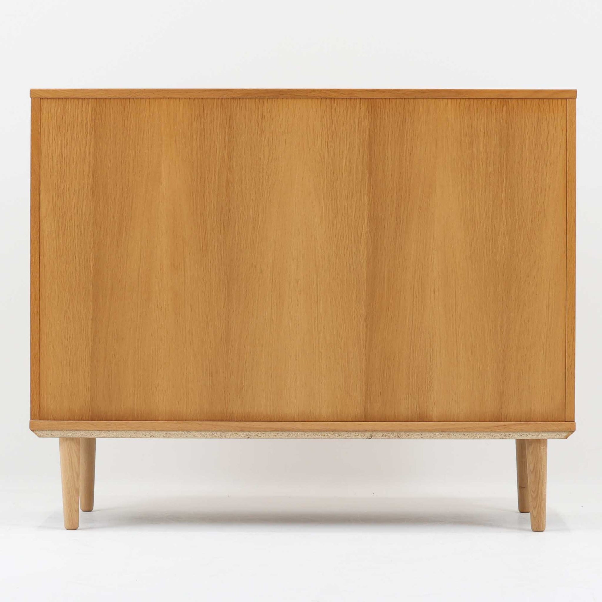 デンマーク製のボードです。温かみのあるオーク材を使用し、滑らかに開閉する蛇腹扉が特徴的な一台。内部は可動棚付きで収納力があり、食器や書類、日用品などをすっきりと収められます。丸みを帯びた脚部が軽やかな印象を与え、幅116cmの程よいサイズ感はリビングやダイニング、書斎にも取り入れやすい設計です。経年により深みを増した木目と丁寧なつくりから、北欧ビンテージならではの質実剛健な魅力が感じられる逸品です。
