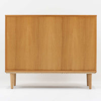 デンマーク製のボードです。温かみのあるオーク材を使用し、滑らかに開閉する蛇腹扉が特徴的な一台。内部は可動棚付きで収納力があり、食器や書類、日用品などをすっきりと収められます。丸みを帯びた脚部が軽やかな印象を与え、幅116cmの程よいサイズ感はリビングやダイニング、書斎にも取り入れやすい設計です。経年により深みを増した木目と丁寧なつくりから、北欧ビンテージならではの質実剛健な魅力が感じられる逸品です。