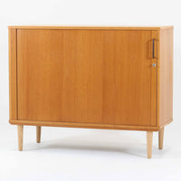 デンマーク製のボードです。温かみのあるオーク材を使用し、滑らかに開閉する蛇腹扉が特徴的な一台。内部は可動棚付きで収納力があり、食器や書類、日用品などをすっきりと収められます。丸みを帯びた脚部が軽やかな印象を与え、幅116cmの程よいサイズ感はリビングやダイニング、書斎にも取り入れやすい設計です。経年により深みを増した木目と丁寧なつくりから、北欧ビンテージならではの質実剛健な魅力が感じられる逸品です。