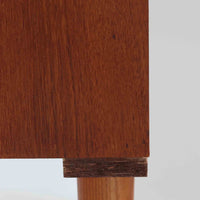 デンマーク製のこちらのローボードは、温かみあるチーク材を用いた端正な佇まいが魅力で、枠組みに厚みをもたせたスライド扉や細身のテーパー脚など、北欧ビンテージらしい上質な意匠が随所に感じられる一台です。内部は左右で棚構成が異なり、日用品から書類、メディア類まで整理しやすく、テレビボードやサイドキャビネットとしても活躍します。経年により深みを増した木肌の美しさと、シンプルながら丁寧に仕上げられた職人技が空間に落ち着きと温もりを添えるビンテージ家具です。