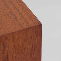 デンマーク製のこちらのローボードは、温かみあるチーク材を用いた端正な佇まいが魅力で、枠組みに厚みをもたせたスライド扉や細身のテーパー脚など、北欧ビンテージらしい上質な意匠が随所に感じられる一台です。内部は左右で棚構成が異なり、日用品から書類、メディア類まで整理しやすく、テレビボードやサイドキャビネットとしても活躍します。経年により深みを増した木肌の美しさと、シンプルながら丁寧に仕上げられた職人技が空間に落ち着きと温もりを添えるビンテージ家具です。