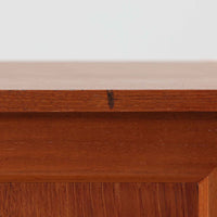 デンマーク製のこちらのローボードは、温かみあるチーク材を用いた端正な佇まいが魅力で、枠組みに厚みをもたせたスライド扉や細身のテーパー脚など、北欧ビンテージらしい上質な意匠が随所に感じられる一台です。内部は左右で棚構成が異なり、日用品から書類、メディア類まで整理しやすく、テレビボードやサイドキャビネットとしても活躍します。経年により深みを増した木肌の美しさと、シンプルながら丁寧に仕上げられた職人技が空間に落ち着きと温もりを添えるビンテージ家具です。