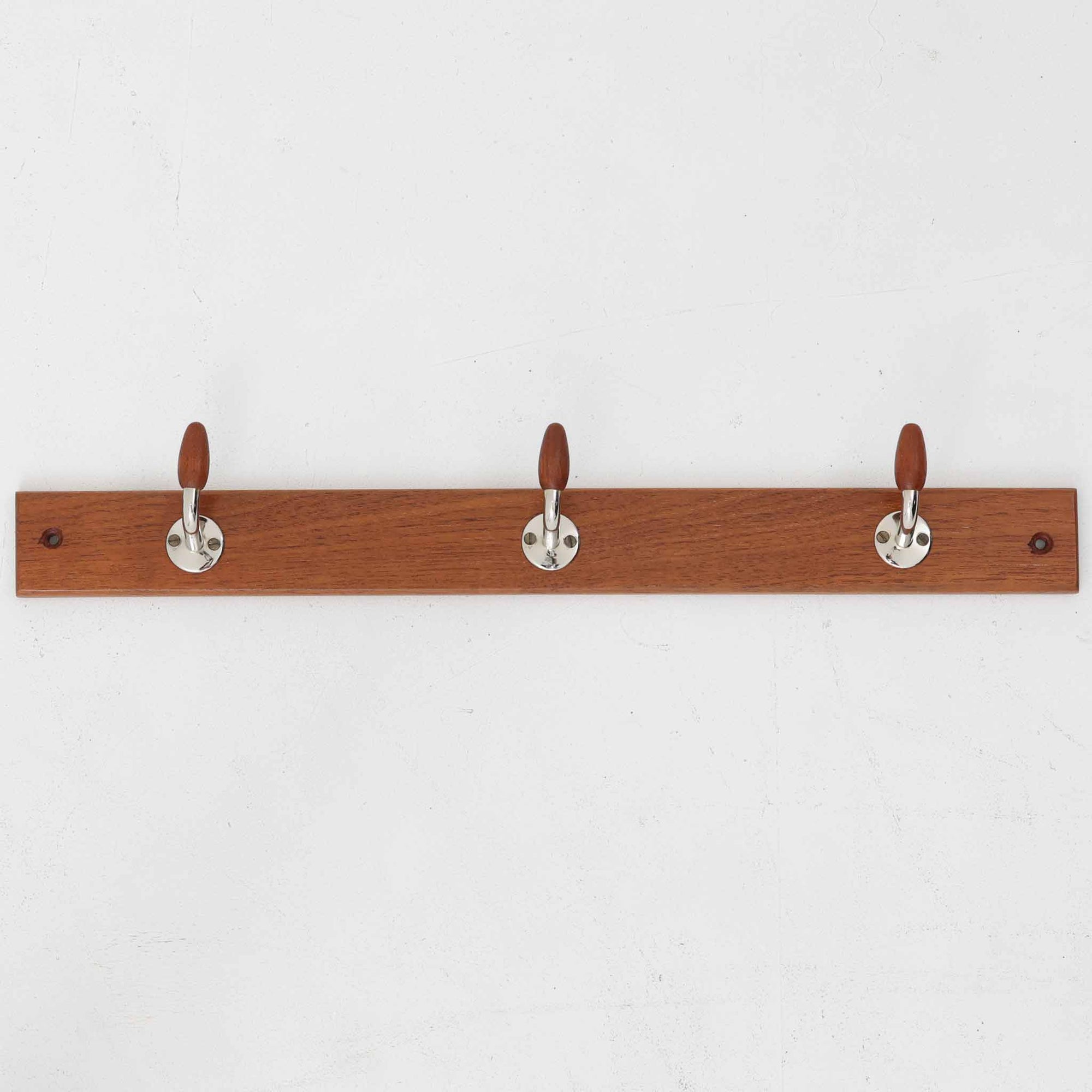 チーク材の温かみあるベースにメタル製の3連フックを組み合わせたデンマーク製のウォールハンガーです。丸みのある木製キャップ付きのフックはコートやバッグを掛けても傷つきにくく、機能性とデザイン性を両立した北欧ビンテージらしいディテールが魅力です。玄関や寝室、ワークスペースなど壁面を活用した収納に便利で、単体での使用はもちろん複数並べて使用しても美しく空間に溶け込みます。ミニマルなデザインでインテリアを選ばず永くお使いいただけるアイテムです。