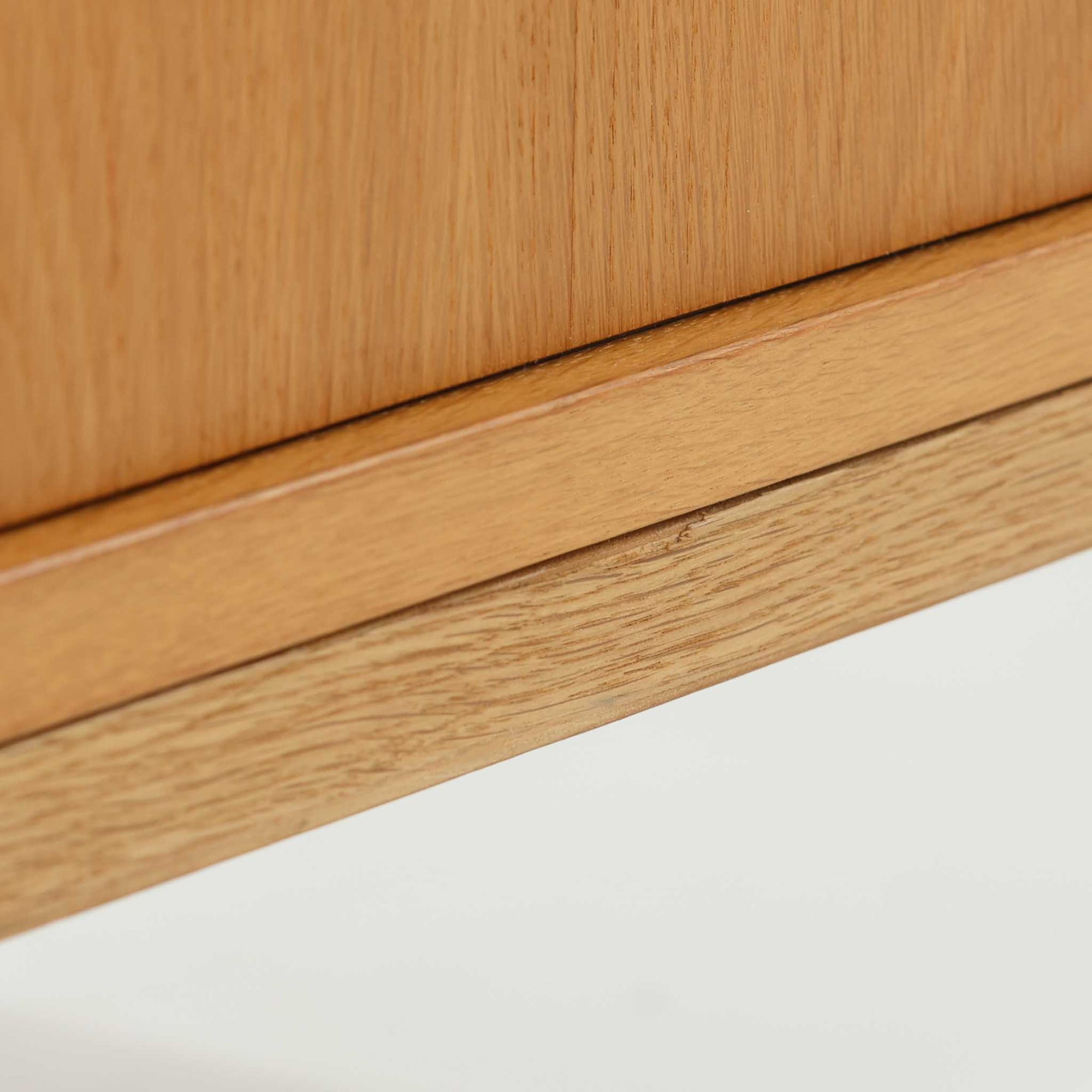 Poul Hundevadがデザインし、Hundevad &amp; Coより製作された蛇腹仕様のサイドボードです。オーク材の穏やかで上品な木目を活かした外観に、横方向へ滑らかに開閉する蛇腹扉を組み合わせた、機能美あふれる一台。扉の開閉時に前後のスペースを取らない構造は、動線を妨げず実用性にも優れています。内部は棚板構成で収納力が高く、食器や書類、リビング周りの小物まで幅広く対応。細身の脚部が全体を軽やかに引き締め、経年によって深みを増した素材感が北欧ビンテージならではの静かな存在感を空間にもたらします。