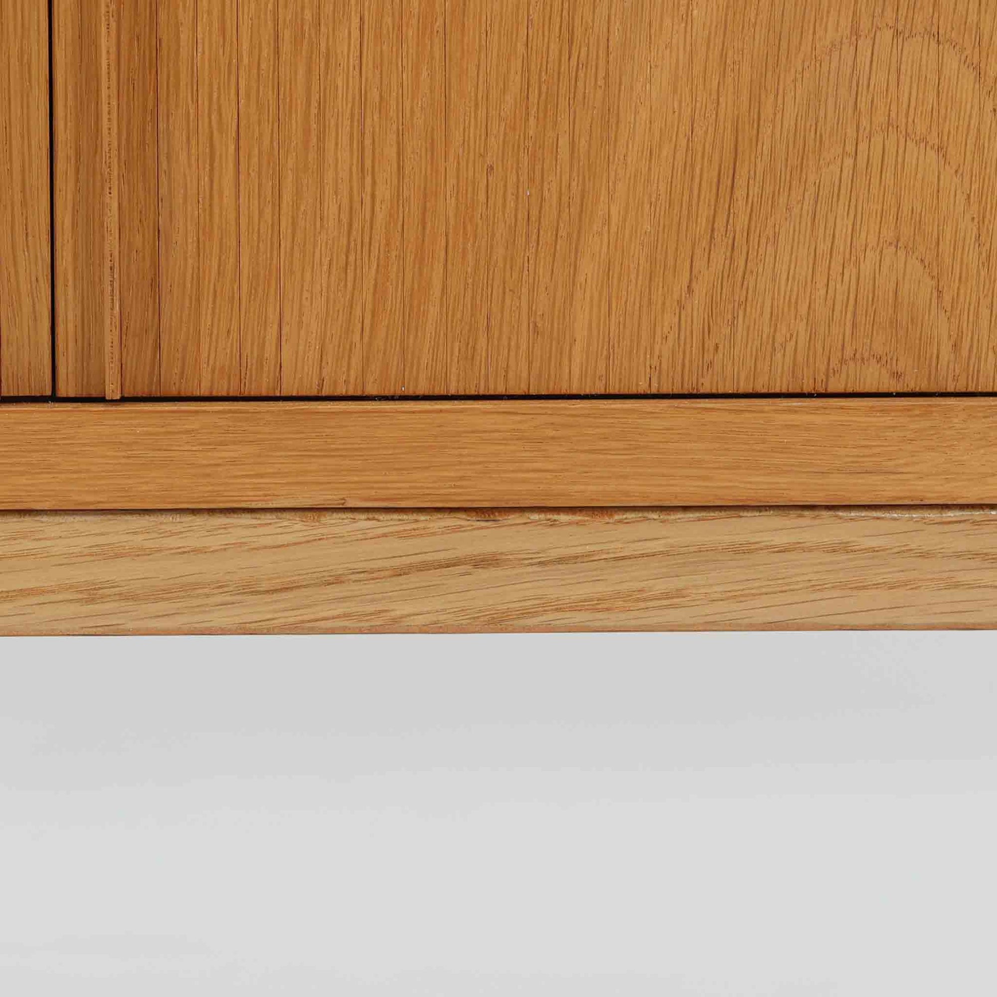 Poul Hundevadがデザインし、Hundevad &amp; Coより製作された蛇腹仕様のサイドボードです。オーク材の穏やかで上品な木目を活かした外観に、横方向へ滑らかに開閉する蛇腹扉を組み合わせた、機能美あふれる一台。扉の開閉時に前後のスペースを取らない構造は、動線を妨げず実用性にも優れています。内部は棚板構成で収納力が高く、食器や書類、リビング周りの小物まで幅広く対応。細身の脚部が全体を軽やかに引き締め、経年によって深みを増した素材感が北欧ビンテージならではの静かな存在感を空間にもたらします。