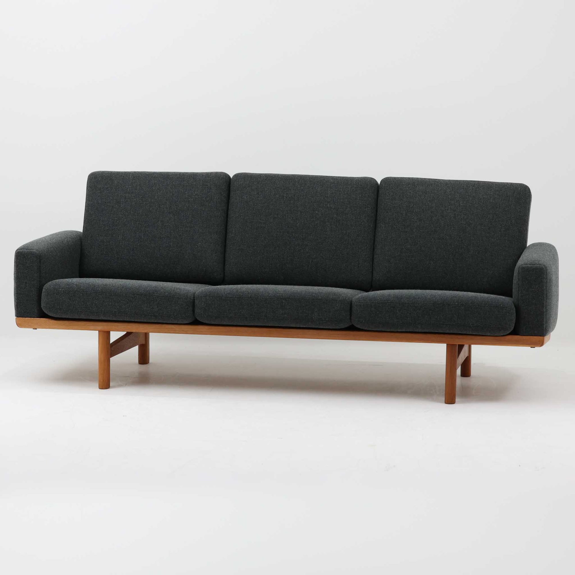 Hans J. Wegnerがデザインし、Getamaより製作された「GE236」トリプルソファです。オーク材のフレームに、背面の横桟が美しく並ぶ構造が特徴で、後ろ姿まで洗練された佇まいを見せるウェグナーらしいデザイン。クッション内部にはスプリングが内包されており、程よい弾力と快適な座り心地を実現しています。落ち着いた色合いの張地が木部の温かな表情を引き立てる、北欧ビンテージを代表する名作ソファです。