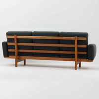 Hans J. Wegnerがデザインし、Getamaより製作された「GE236」トリプルソファです。オーク材のフレームに、背面の横桟が美しく並ぶ構造が特徴で、後ろ姿まで洗練された佇まいを見せるウェグナーらしいデザイン。クッション内部にはスプリングが内包されており、程よい弾力と快適な座り心地を実現しています。落ち着いた色合いの張地が木部の温かな表情を引き立てる、北欧ビンテージを代表する名作ソファです。