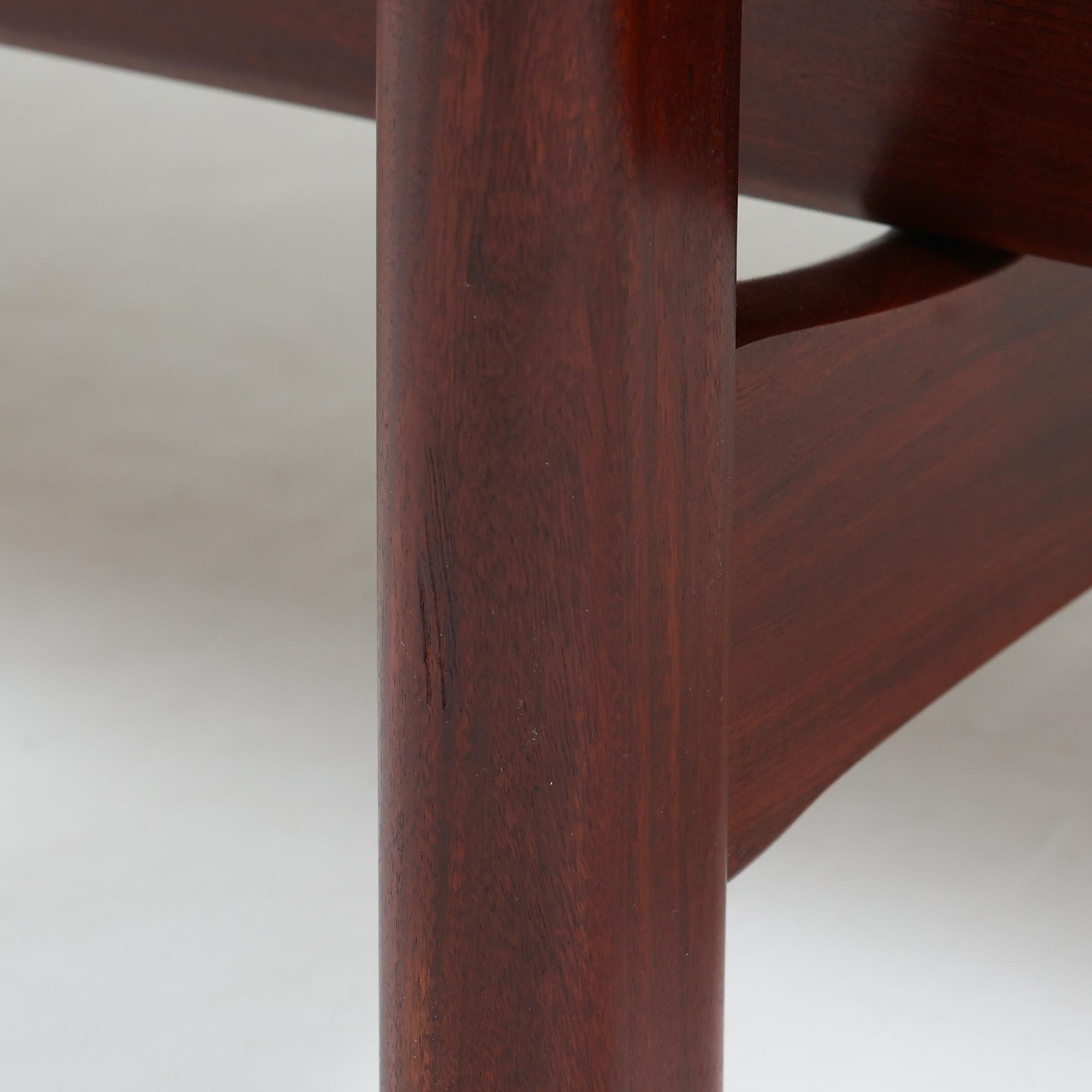 こちらは、ウェグナーデザインの人気モデル、GE236の3人掛けソファです。後ろ姿が非常に美しいため、あえて壁に寄せず背面を見せる配置もおすすめです。クッション内部にはスプリングが内蔵されており、座り心地も良好です。さらに、こちらは現地でも希少なアフロモシア材（通称アフリカンチーク）が使用された特別なモデルです。GE236のチーク材仕様として一般的に認識されているのは、このアフロモシア材が使用されたモデルを指します。GETAMA社の刻印も確認できます。