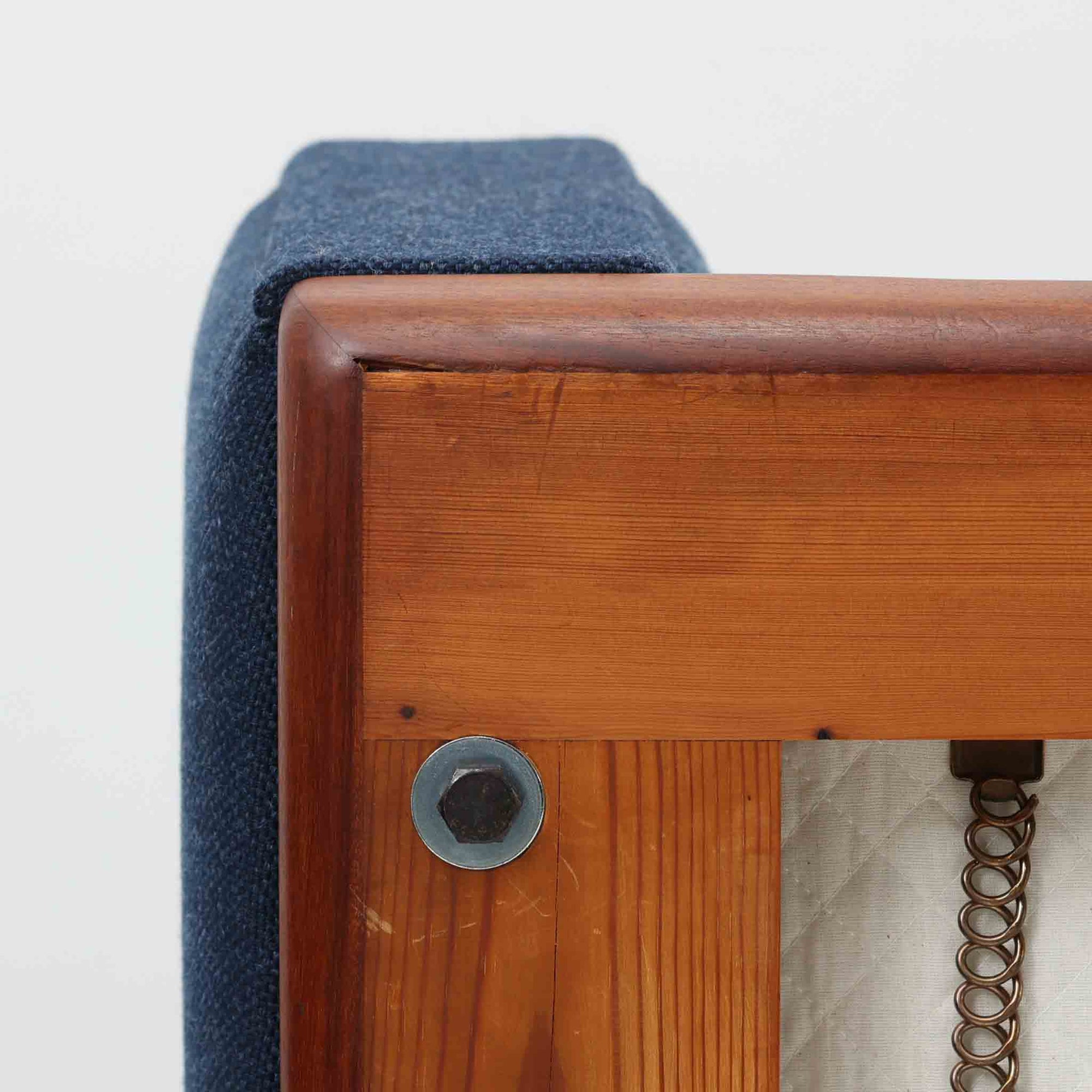 こちらは、ウェグナーデザインの人気モデル、GE236の3人掛けソファです。後ろ姿が非常に美しいため、あえて壁に寄せず背面を見せる配置もおすすめです。クッション内部にはスプリングが内蔵されており、座り心地も良好です。さらに、こちらは現地でも希少なアフロモシア材（通称アフリカンチーク）が使用された特別なモデルです。GE236のチーク材仕様として一般的に認識されているのは、このアフロモシア材が使用されたモデルを指します。GETAMA社の刻印も確認できます。