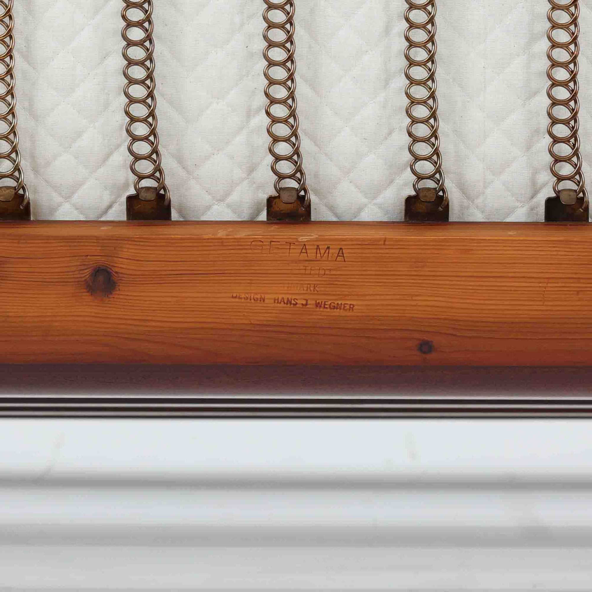 こちらは、ウェグナーデザインの人気モデル、GE236の3人掛けソファです。後ろ姿が非常に美しいため、あえて壁に寄せず背面を見せる配置もおすすめです。クッション内部にはスプリングが内蔵されており、座り心地も良好です。さらに、こちらは現地でも希少なアフロモシア材（通称アフリカンチーク）が使用された特別なモデルです。GE236のチーク材仕様として一般的に認識されているのは、このアフロモシア材が使用されたモデルを指します。GETAMA社の刻印も確認できます。