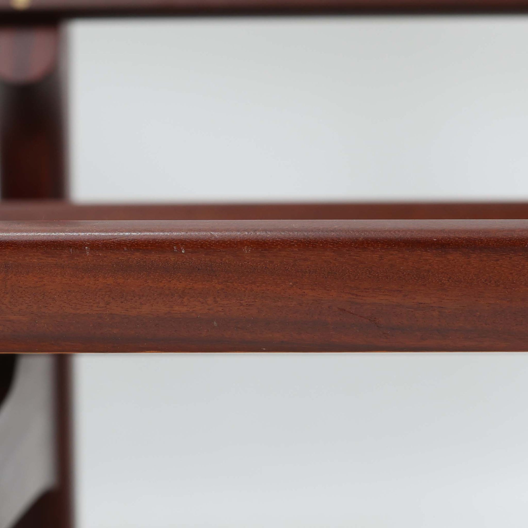 こちらは、ウェグナーデザインの人気モデル、GE236の3人掛けソファです。後ろ姿が非常に美しいため、あえて壁に寄せず背面を見せる配置もおすすめです。クッション内部にはスプリングが内蔵されており、座り心地も良好です。さらに、こちらは現地でも希少なアフロモシア材（通称アフリカンチーク）が使用された特別なモデルです。GE236のチーク材仕様として一般的に認識されているのは、このアフロモシア材が使用されたモデルを指します。GETAMA社の刻印も確認できます。