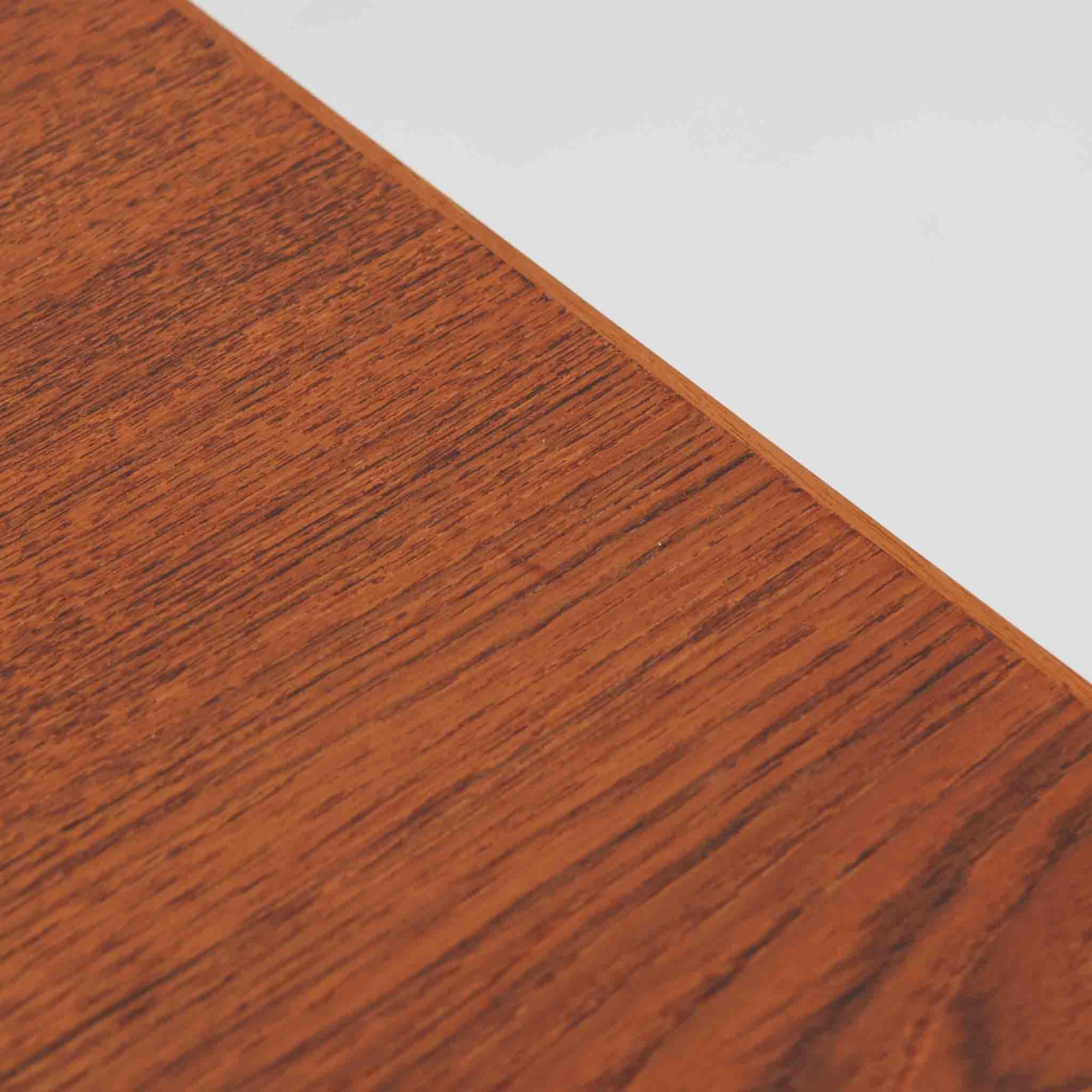 デンマーク製ローボードです。チーク材ならではの赤みを帯びた美しい木目が前面にあらわれ、引き戸には掘り込み式の丸い取っ手を配したミニマルな意匠が北欧らしい静かな存在感を放ちます。幅80cmの小ぶりなサイズ感で、リビングのテレビ台としてはもちろん、書斎やベッドルームでの収納家具としても取り入れやすく、内部には棚板を備え実用性も十分です。経年によって深みを増した木肌の表情と丁寧なつくりが、ビンテージならではの温もりを空間に添えてくれる一台です。