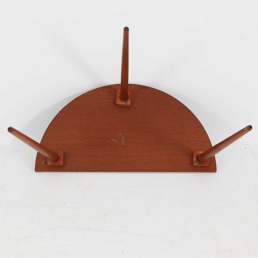 デンマーク製サイドテーブルです。チーク材を使用し、滑らかな半円形の天板とすらりと伸びた3本の円錐脚が軽やかな印象を与えます。北欧デザインらしいミニマルな造形ながら、チーク材の温かみと艶が経年変化によって美しく際立っています。ソファ横やベッドサイドなど、限られたスペースにも馴染むサイズ感で、花瓶やランプを置く飾り台としてもおすすめの一台です。