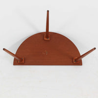 デンマーク製サイドテーブルです。チーク材を使用し、滑らかな半円形の天板とすらりと伸びた3本の円錐脚が軽やかな印象を与えます。北欧デザインらしいミニマルな造形ながら、チーク材の温かみと艶が経年変化によって美しく際立っています。ソファ横やベッドサイドなど、限られたスペースにも馴染むサイズ感で、花瓶やランプを置く飾り台としてもおすすめの一台です。