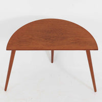 デンマーク製サイドテーブルです。チーク材を使用し、滑らかな半円形の天板とすらりと伸びた3本の円錐脚が軽やかな印象を与えます。北欧デザインらしいミニマルな造形ながら、チーク材の温かみと艶が経年変化によって美しく際立っています。ソファ横やベッドサイドなど、限られたスペースにも馴染むサイズ感で、花瓶やランプを置く飾り台としてもおすすめの一台です。