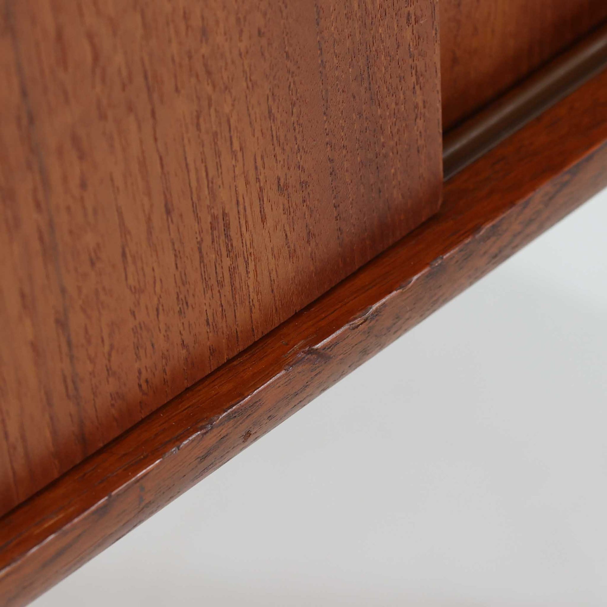 北欧ビンテージらしい端正な佇まいが魅力の小ぶりなボードです。深みのある色合いが美しいチーク材が用いられ、木目の表情と経年変化による艶感が空間に落ち着きを与えます。引き戸仕様の扉は前後にスペースを取らず、限られた空間でも扱いやすい構造です。内部には棚板を備え、食器や書類、小物類まですっきりと収納可能。幅80cmのコンパクトなサイズ感は、リビングのサブ収納や玄関、書斎など多用途に活躍し、北欧家具ならではの実用性と素材の良さを感じさせる一台です。