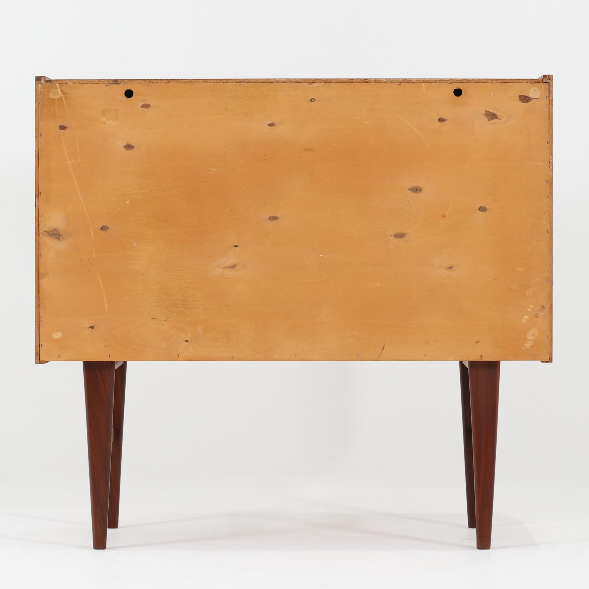 北欧ビンテージらしい端正な佇まいが魅力の小ぶりなボードです。深みのある色合いが美しいチーク材が用いられ、木目の表情と経年変化による艶感が空間に落ち着きを与えます。引き戸仕様の扉は前後にスペースを取らず、限られた空間でも扱いやすい構造です。内部には棚板を備え、食器や書類、小物類まですっきりと収納可能。幅80cmのコンパクトなサイズ感は、リビングのサブ収納や玄関、書斎など多用途に活躍し、北欧家具ならではの実用性と素材の良さを感じさせる一台です。