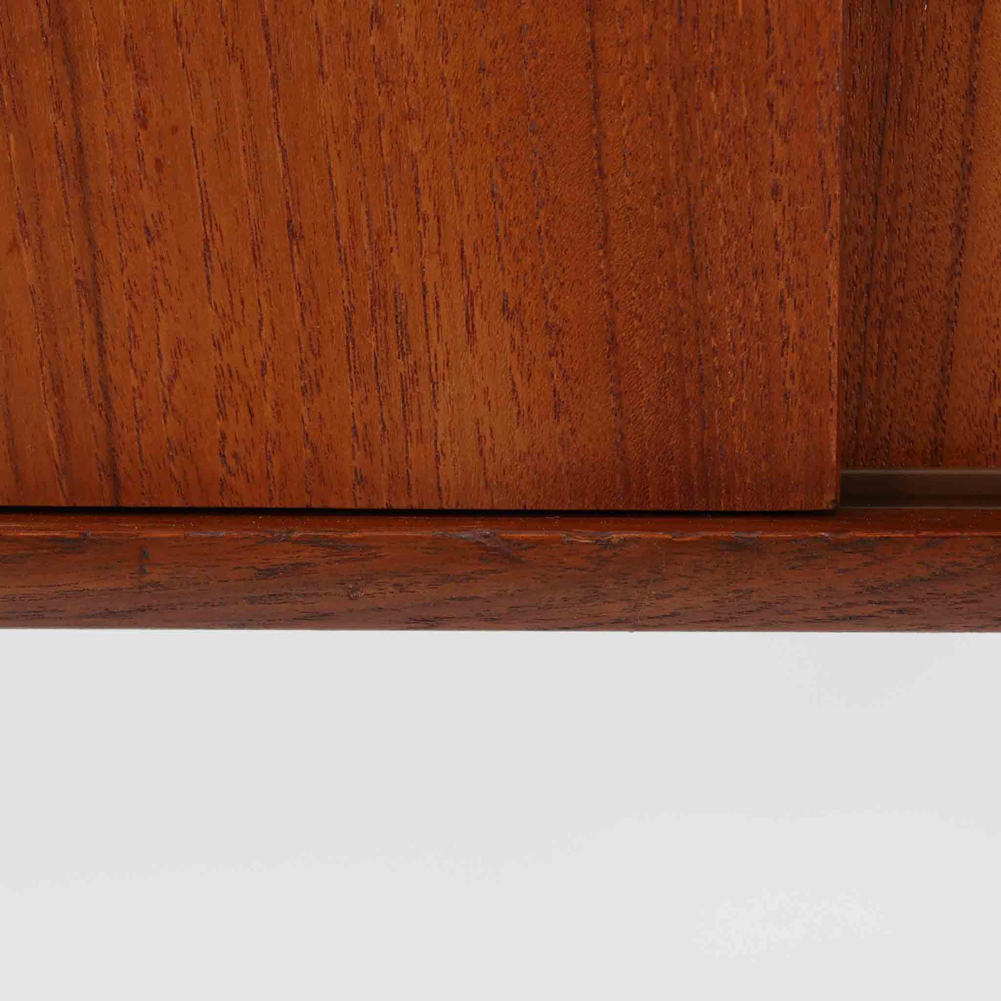 北欧ビンテージらしい端正な佇まいが魅力の小ぶりなボードです。深みのある色合いが美しいチーク材が用いられ、木目の表情と経年変化による艶感が空間に落ち着きを与えます。引き戸仕様の扉は前後にスペースを取らず、限られた空間でも扱いやすい構造です。内部には棚板を備え、食器や書類、小物類まですっきりと収納可能。幅80cmのコンパクトなサイズ感は、リビングのサブ収納や玄関、書斎など多用途に活躍し、北欧家具ならではの実用性と素材の良さを感じさせる一台です。