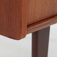 北欧ビンテージらしい端正な佇まいが魅力の小ぶりなボードです。深みのある色合いが美しいチーク材が用いられ、木目の表情と経年変化による艶感が空間に落ち着きを与えます。引き戸仕様の扉は前後にスペースを取らず、限られた空間でも扱いやすい構造です。内部には棚板を備え、食器や書類、小物類まですっきりと収納可能。幅80cmのコンパクトなサイズ感は、リビングのサブ収納や玄関、書斎など多用途に活躍し、北欧家具ならではの実用性と素材の良さを感じさせる一台です。