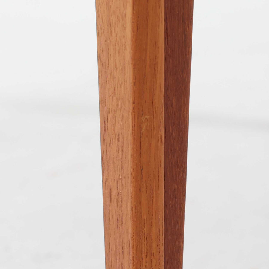 デンマークの巨匠フィン・ユールによるデザイン、France & Son社製のサイドテーブル「FD635」です。ロゴより1957～1960年代前半に製造されたと推測される本品は、チーク無垢材を贅沢に使用し、滑らかな脚部の曲線と柔らかなエッジラインが見事に調和した美しいデザインが魅力です。天板の縁にはわずかな立ち上がりが設けられ、機能性と造形美を兼ね備えた構造となっています。彫刻的ともいえる有機的なフォルムはフィン・ユールの真骨頂であり、リビングやベッドサイドで北欧家具の上質な存在感を引き立てる逸品です。