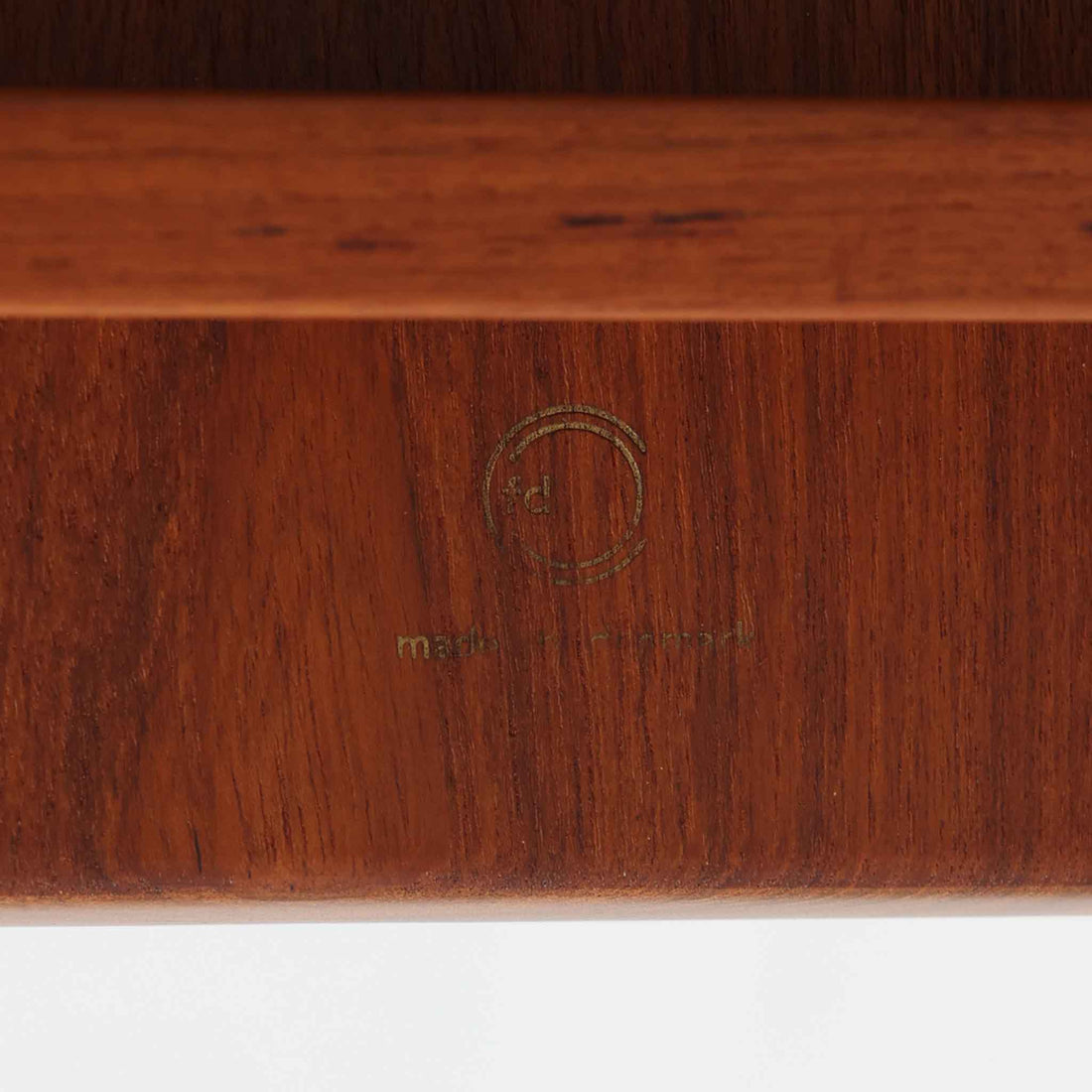 デンマークの巨匠フィン・ユールによるデザイン、France & Son社製のサイドテーブル「FD635」です。ロゴより1957～1960年代前半に製造されたと推測される本品は、チーク無垢材を贅沢に使用し、滑らかな脚部の曲線と柔らかなエッジラインが見事に調和した美しいデザインが魅力です。天板の縁にはわずかな立ち上がりが設けられ、機能性と造形美を兼ね備えた構造となっています。彫刻的ともいえる有機的なフォルムはフィン・ユールの真骨頂であり、リビングやベッドサイドで北欧家具の上質な存在感を引き立てる逸品です。