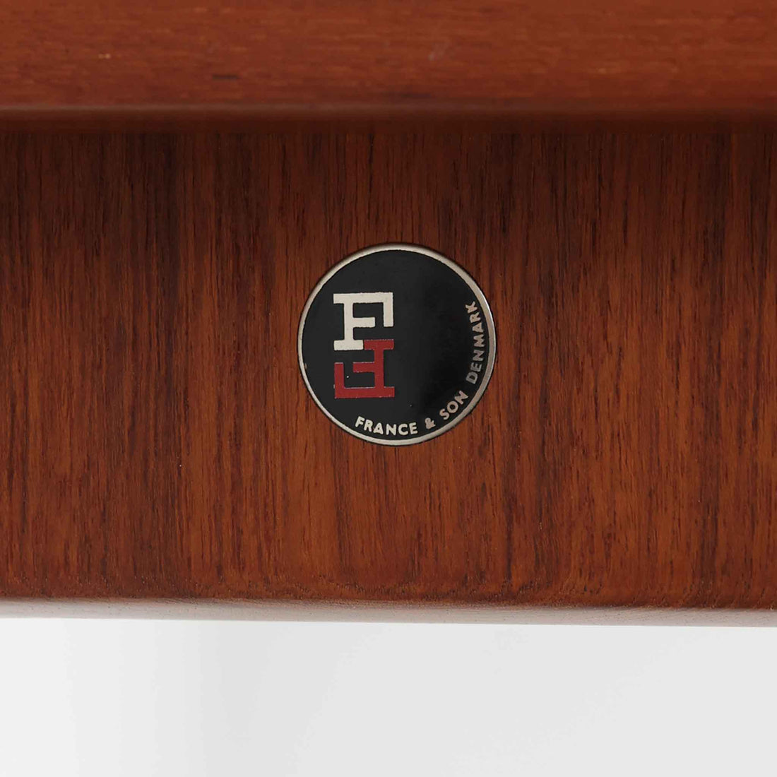 デンマークの巨匠フィン・ユールによるデザイン、France & Son社製のサイドテーブル「FD635」です。ロゴより1957～1960年代前半に製造されたと推測される本品は、チーク無垢材を贅沢に使用し、滑らかな脚部の曲線と柔らかなエッジラインが見事に調和した美しいデザインが魅力です。天板の縁にはわずかな立ち上がりが設けられ、機能性と造形美を兼ね備えた構造となっています。彫刻的ともいえる有機的なフォルムはフィン・ユールの真骨頂であり、リビングやベッドサイドで北欧家具の上質な存在感を引き立てる逸品です。