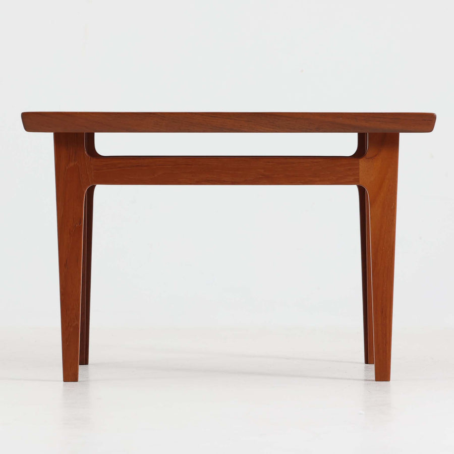 デンマークの巨匠フィン・ユールによるデザイン、France & Son社製のサイドテーブル「FD635」です。ロゴより1957～1960年代前半に製造されたと推測される本品は、チーク無垢材を贅沢に使用し、滑らかな脚部の曲線と柔らかなエッジラインが見事に調和した美しいデザインが魅力です。天板の縁にはわずかな立ち上がりが設けられ、機能性と造形美を兼ね備えた構造となっています。彫刻的ともいえる有機的なフォルムはフィン・ユールの真骨頂であり、リビングやベッドサイドで北欧家具の上質な存在感を引き立てる逸品です。