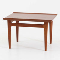 デンマークの巨匠フィン・ユールによるデザイン、France & Son社製のサイドテーブル「FD635」です。ロゴより1957～1960年代前半に製造されたと推測される本品は、チーク無垢材を贅沢に使用し、滑らかな脚部の曲線と柔らかなエッジラインが見事に調和した美しいデザインが魅力です。天板の縁にはわずかな立ち上がりが設けられ、機能性と造形美を兼ね備えた構造となっています。彫刻的ともいえる有機的なフォルムはフィン・ユールの真骨頂であり、リビングやベッドサイドで北欧家具の上質な存在感を引き立てる逸品です。