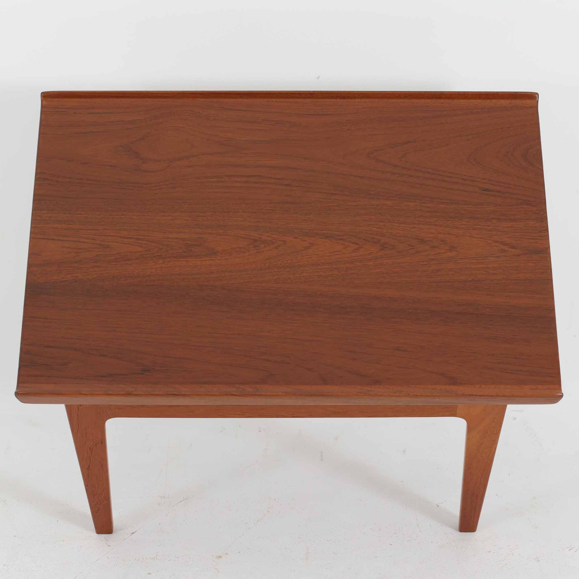 デンマークの巨匠フィン・ユールによるデザイン、France &amp; Son社製のサイドテーブル「FD635」です。ロゴより1957～1960年代前半に製造されたと推測される本品は、チーク無垢材を贅沢に使用し、滑らかな脚部の曲線と柔らかなエッジラインが見事に調和した美しいデザインが魅力です。天板の縁にはわずかな立ち上がりが設けられ、機能性と造形美を兼ね備えた構造となっています。彫刻的ともいえる有機的なフォルムはフィン・ユールの真骨頂であり、リビングやベッドサイドで北欧家具の上質な存在感を引き立てる逸品です。