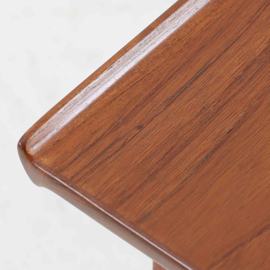 デンマークの巨匠フィン・ユールによるデザイン、France & Son社製のサイドテーブル「FD635」です。ロゴより1957～1960年代前半に製造されたと推測される本品は、チーク無垢材を贅沢に使用し、滑らかな脚部の曲線と柔らかなエッジラインが見事に調和した美しいデザインが魅力です。天板の縁にはわずかな立ち上がりが設けられ、機能性と造形美を兼ね備えた構造となっています。彫刻的ともいえる有機的なフォルムはフィン・ユールの真骨頂であり、リビングやベッドサイドで北欧家具の上質な存在感を引き立てる逸品です。