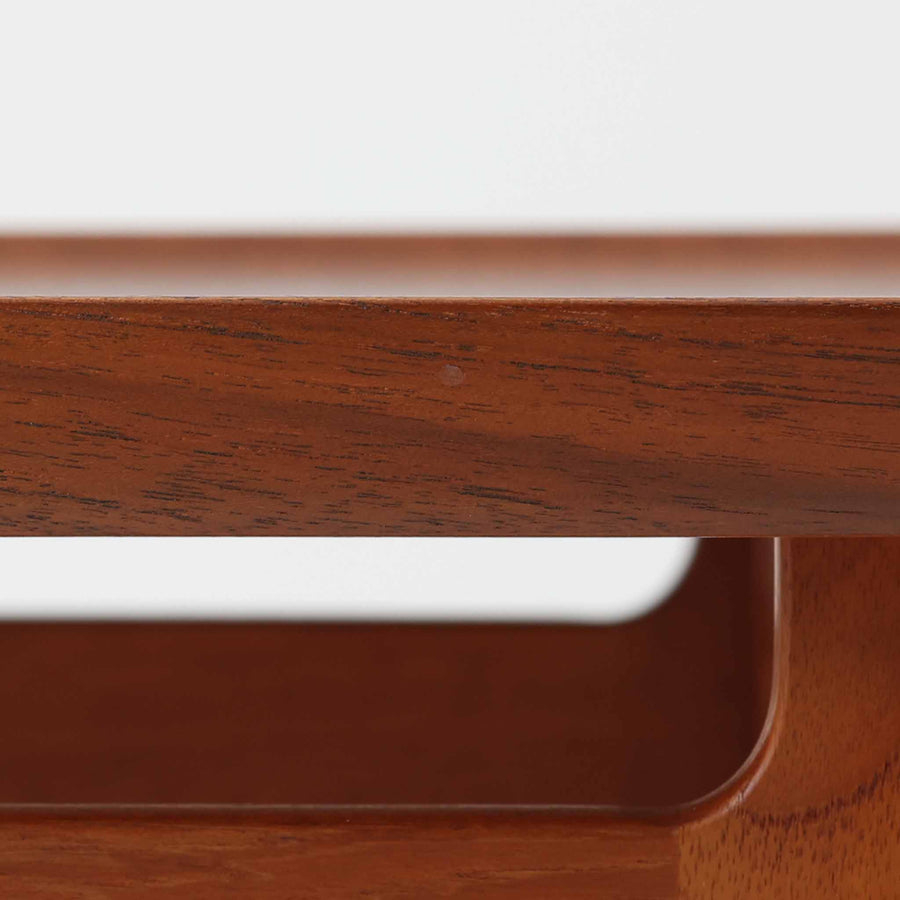 デンマークの巨匠フィン・ユールによるデザイン、France & Son社製のサイドテーブル「FD635」です。ロゴより1957～1960年代前半に製造されたと推測される本品は、チーク無垢材を贅沢に使用し、滑らかな脚部の曲線と柔らかなエッジラインが見事に調和した美しいデザインが魅力です。天板の縁にはわずかな立ち上がりが設けられ、機能性と造形美を兼ね備えた構造となっています。彫刻的ともいえる有機的なフォルムはフィン・ユールの真骨頂であり、リビングやベッドサイドで北欧家具の上質な存在感を引き立てる逸品です。