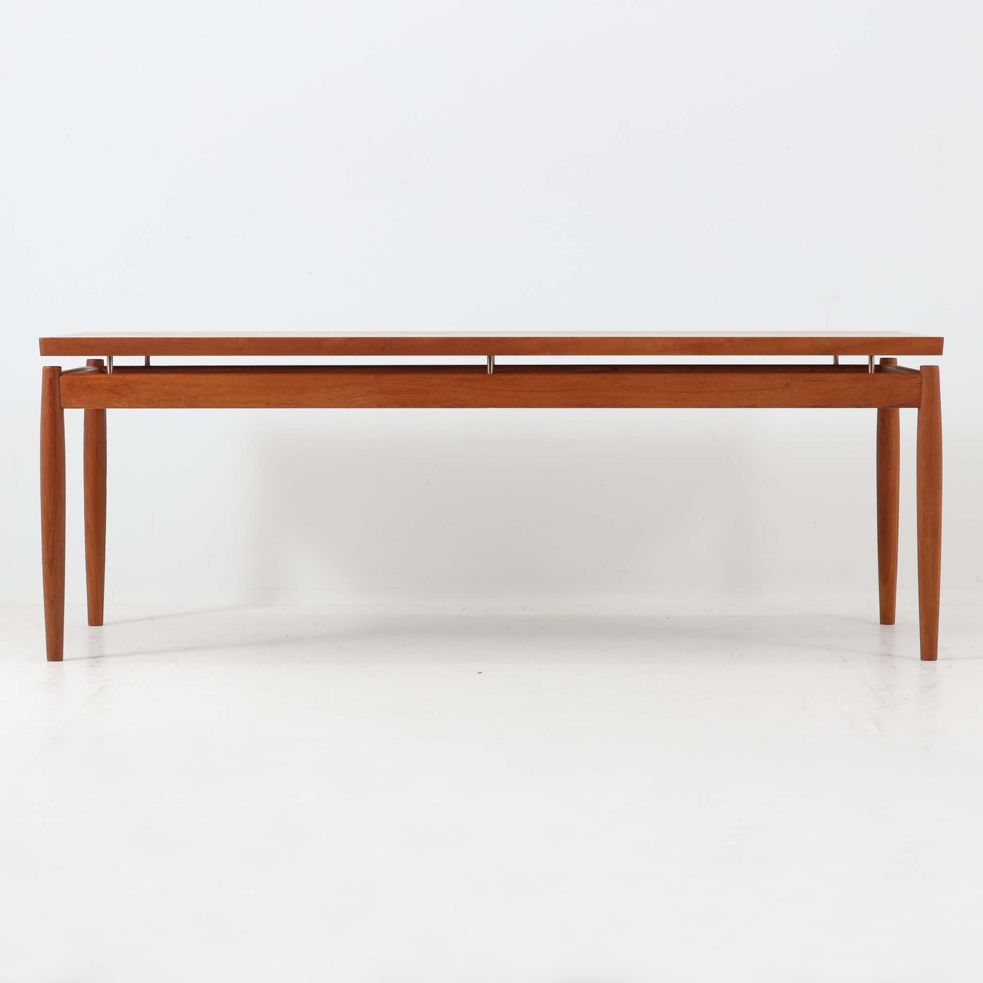 Grete Jalk（グレーテ・ヤルク）によるデザイン、France & Son社製のセンターテーブル Model 622/54です。繊細なテーパードレッグに天板と幕板の隙間を持たせた軽やかな構造が美しく、真鍮パーツがアクセントとして上質な存在感を添えています。幅150cmのゆったりとしたサイズはリビングでの使用に最適で、ソファ前のテーブルとしてはもちろん展示台としてもバランスよく馴染みます。北欧モダンを象徴する端正なラインとチーク材の豊かな木目が魅力で、ロゴプレートの仕様より1960年代半ば〜1969年頃に製造された個体と推測され、ミッドセンチュリー期を代表する名作ビンテージ家具です。