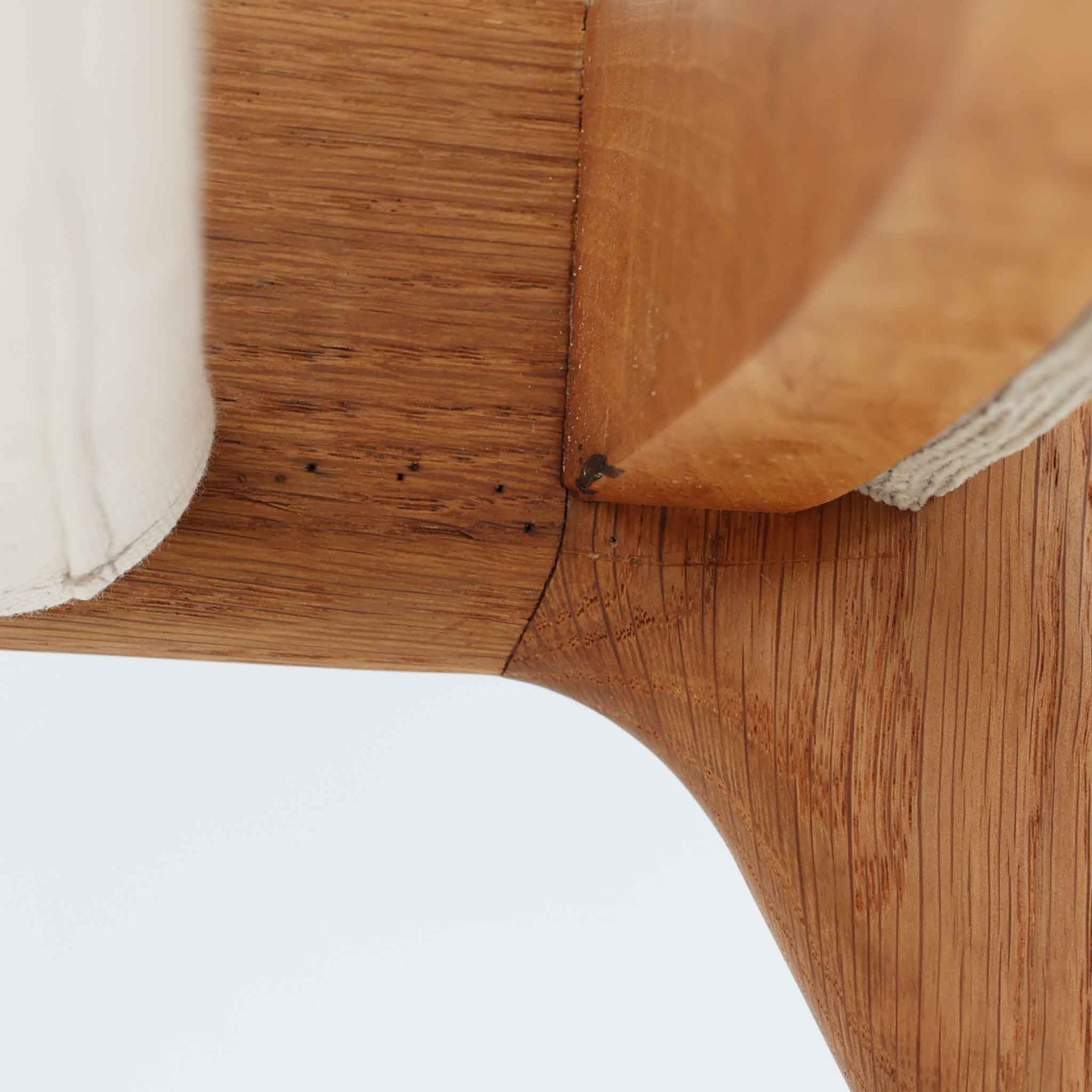 Hans J. Wegnerがデザインし、AP Stolenが製作したAP15ハイバックシングルソファです。オーク材の滑らかな木肌を活かしたフレームに、包み込むような背とヘッドレストを備えた優美なフォルムが印象的。彫刻的なアーム形状や前後に傾斜した脚部など、随所にウェグナーらしい造形美が感じられます。ホワイト系の色味が空間を明るく上品な印象に整えます。ゆったりと身体を預けられる快適な座り心地と、経年で深みを増した木部の風合いが格調ある雰囲気をもたらす北欧ビンテージの名品です。