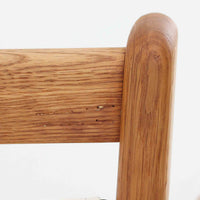 Hans J. Wegnerがデザインし、AP Stolenが製作したAP15ハイバックシングルソファです。オーク材の滑らかな木肌を活かしたフレームに、包み込むような背とヘッドレストを備えた優美なフォルムが印象的。彫刻的なアーム形状や前後に傾斜した脚部など、随所にウェグナーらしい造形美が感じられます。ホワイト系の色味が空間を明るく上品な印象に整えます。ゆったりと身体を預けられる快適な座り心地と、経年で深みを増した木部の風合いが格調ある雰囲気をもたらす北欧ビンテージの名品です。