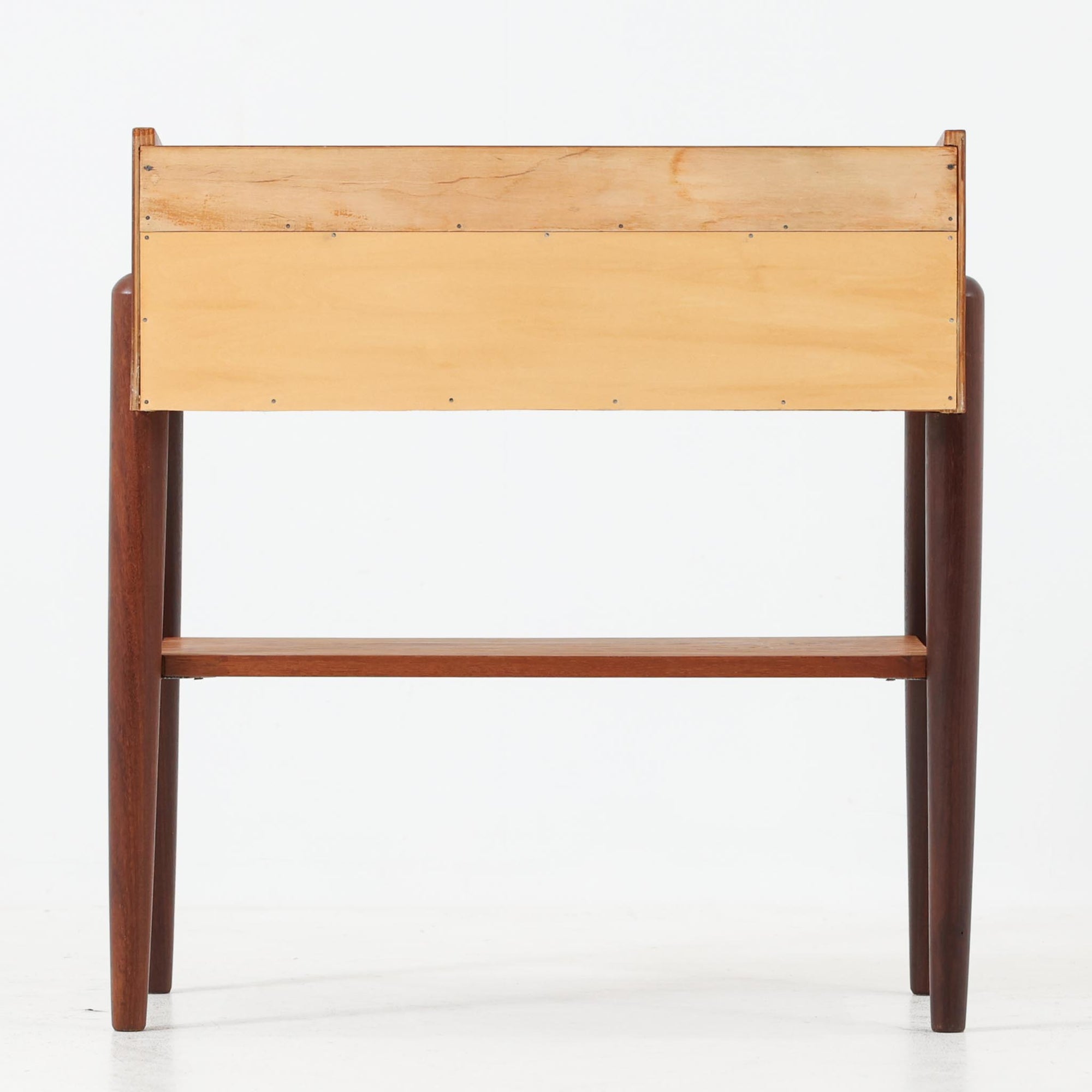 デンマーク製のサイドチェストです。チーク材ならではの温かみある木目と落ち着いた色合いが美しく、側板を立ち上げた天板形状がさりげないデザインアクセントになっています。引き出しには手掛けとして一体成形された取っ手があしらわれ、滑らかな開閉とすっきりとした正面意匠を両立しています。幅52cmの扱いやすいサイズ感で、ベッドサイドやソファ脇、玄関先などにも取り入れやすく、下段の棚板は本や小物の収納にも便利です。経年変化によって深みを増したチークの表情が、ビンテージならではの落ち着いた存在感を空間にもたらします。