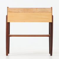 デンマーク製のサイドチェストです。チーク材ならではの温かみある木目と落ち着いた色合いが美しく、側板を立ち上げた天板形状がさりげないデザインアクセントになっています。引き出しには手掛けとして一体成形された取っ手があしらわれ、滑らかな開閉とすっきりとした正面意匠を両立しています。幅52cmの扱いやすいサイズ感で、ベッドサイドやソファ脇、玄関先などにも取り入れやすく、下段の棚板は本や小物の収納にも便利です。経年変化によって深みを増したチークの表情が、ビンテージならではの落ち着いた存在感を空間にもたらします。