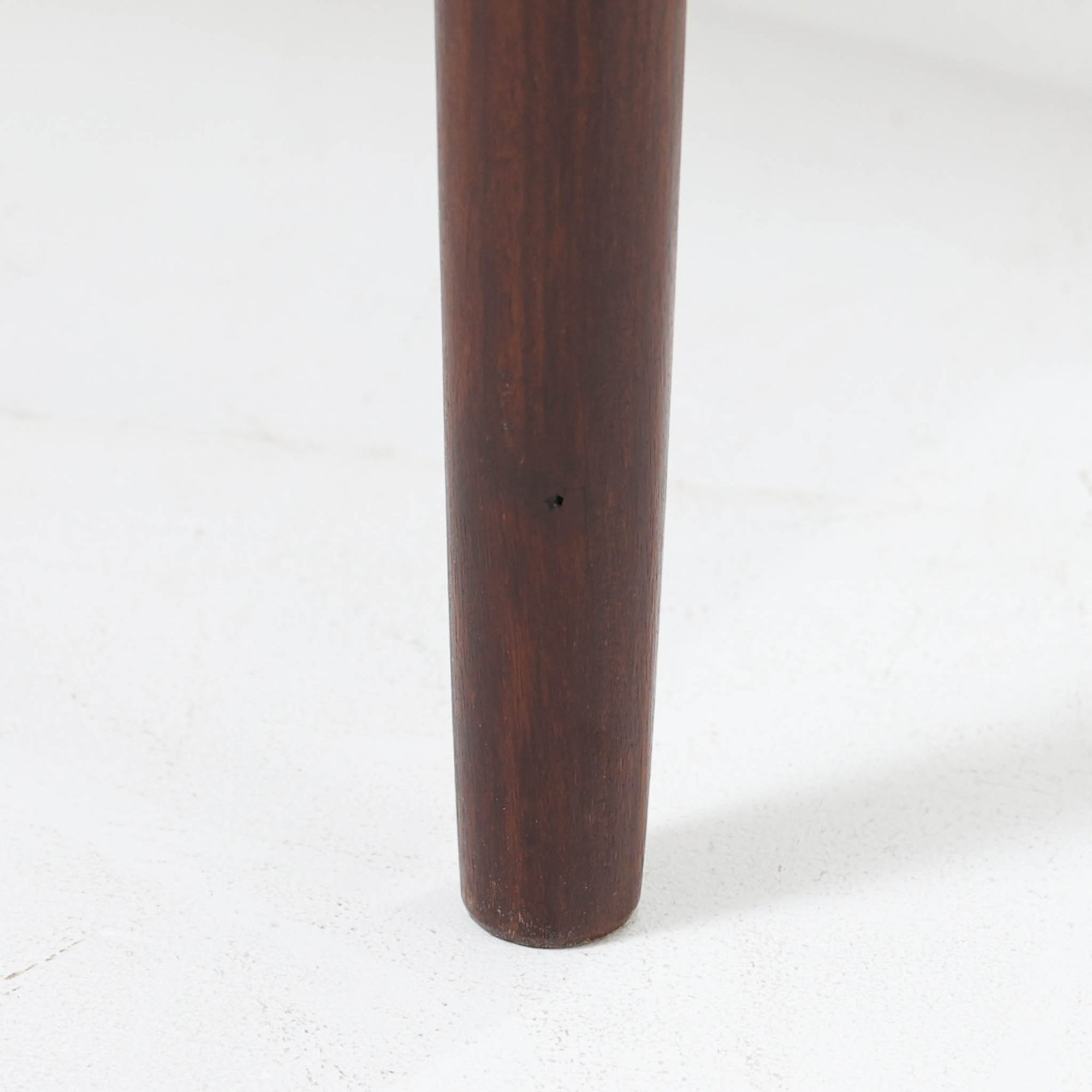 デンマーク製のサイドチェストです。チーク材ならではの温かみある木目と落ち着いた色合いが美しく、側板を立ち上げた天板形状がさりげないデザインアクセントになっています。引き出しには手掛けとして一体成形された取っ手があしらわれ、滑らかな開閉とすっきりとした正面意匠を両立しています。幅52cmの扱いやすいサイズ感で、ベッドサイドやソファ脇、玄関先などにも取り入れやすく、下段の棚板は本や小物の収納にも便利です。経年変化によって深みを増したチークの表情が、ビンテージならではの落ち着いた存在感を空間にもたらします。