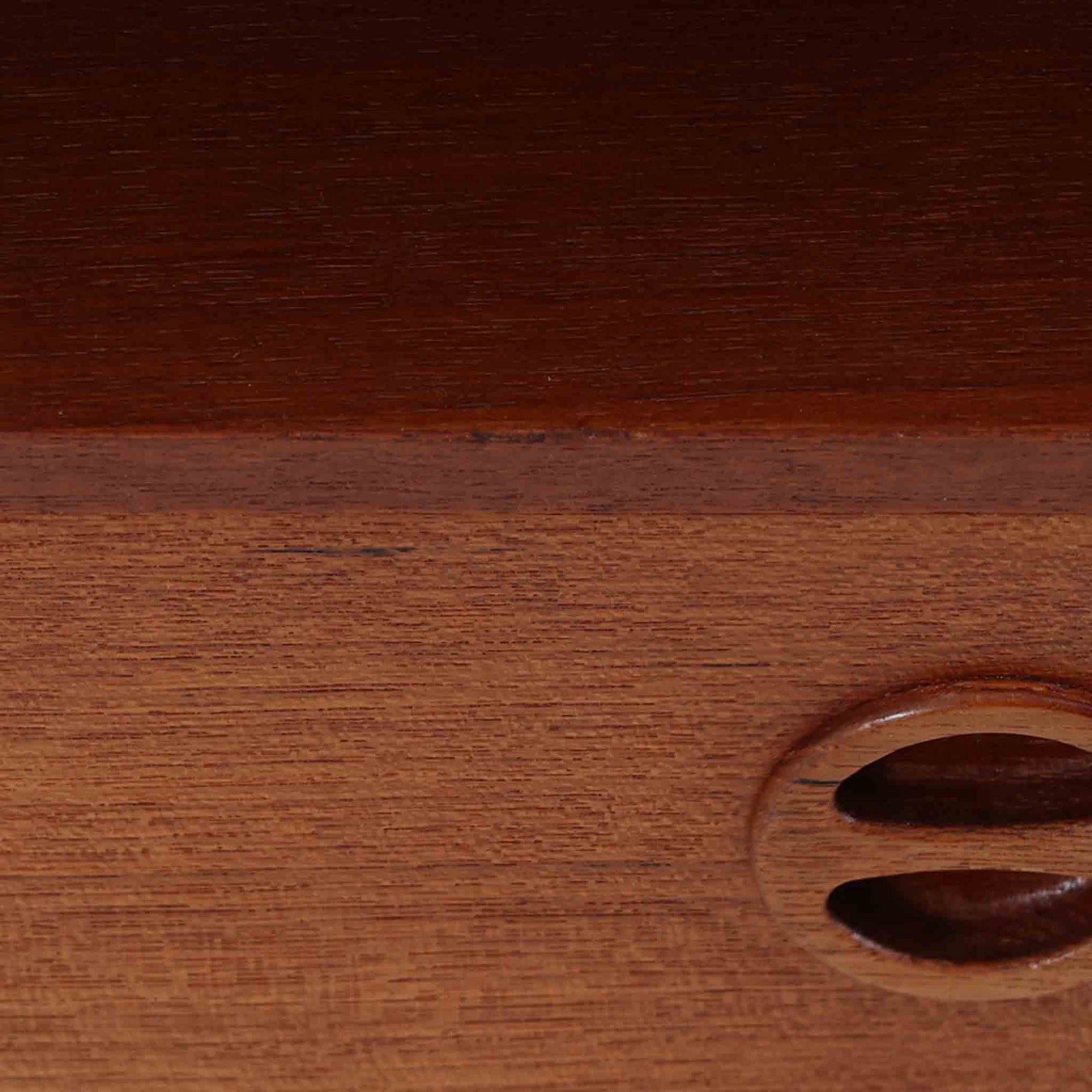 デンマーク製のサイドチェストで、温かみのあるチーク材を用いた北欧ビンテージらしい佇まいが魅力です。上段のオープンスペースは読みかけの本や小物の収納に便利で、下段の引き出しにはアイコン的な丸型取手があしらわれ、シンプルな中にも愛嬌のあるアクセントを添えています。細く伸びたテーパードレッグが軽やかな印象を与え、ベッドサイドやソファ横のサイドテーブルとしても活躍。経年変化による深い色艶が空間に上質な雰囲気をもたらすビンテージ家具です。