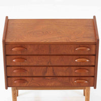 チーク材とオーク材を組み合わせた4段チェストです。前板には美しい木目を持つチーク材、脚部には明るく堅牢なオーク材が用いられ、素材のコントラストが北欧らしい洗練された印象を与えます。緩やかな曲線を描く取手や、すっきりとしたプロポーションが全体を端正にまとめ、コンパクトな幅59cmながら十分な収納力を備えています。リビングや寝室、書斎などさまざまな空間に取り入れやすく、ビンテージならではの風合いと実用性を兼ね備えた一台です。