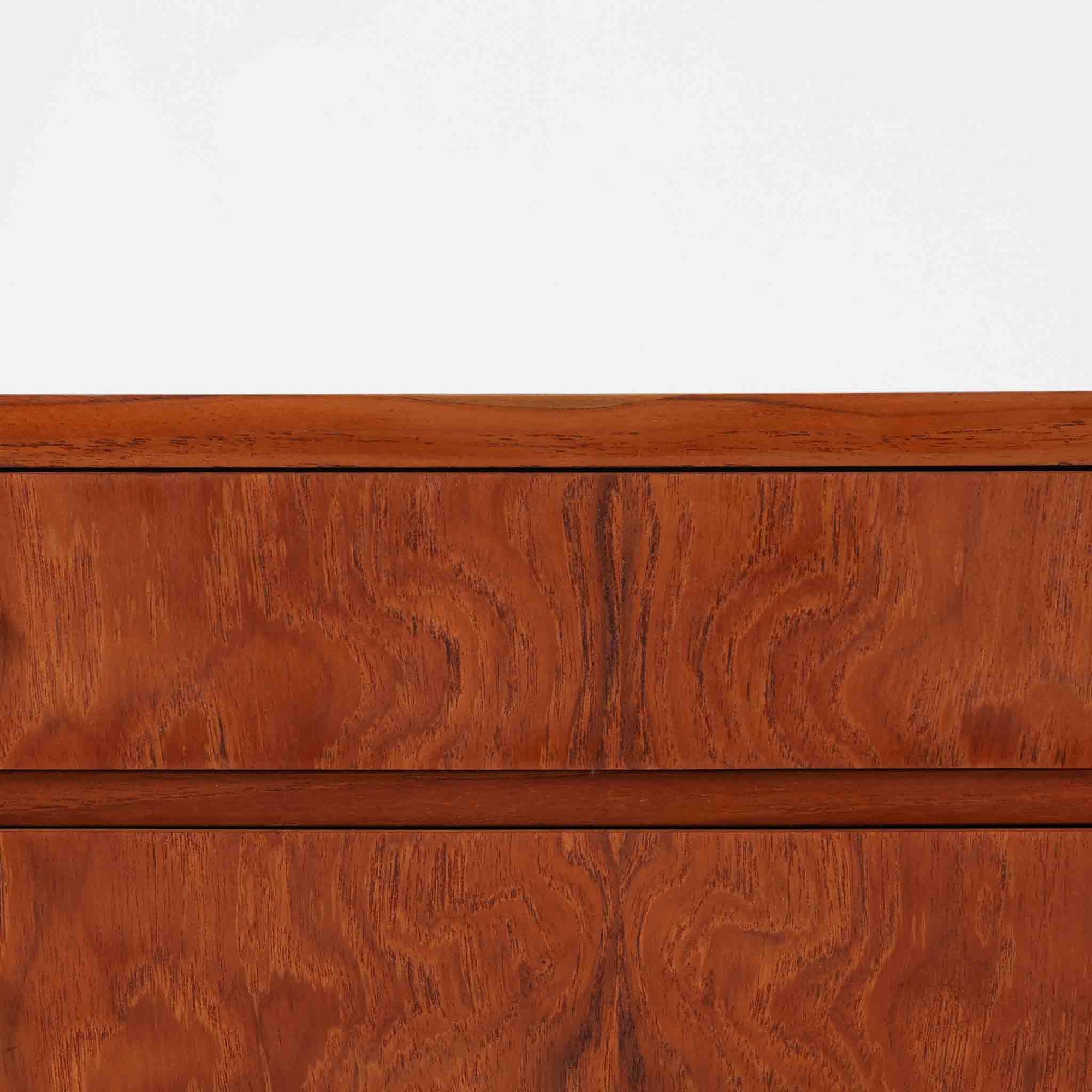 チーク材とオーク材を組み合わせた4段チェストです。前板には美しい木目を持つチーク材、脚部には明るく堅牢なオーク材が用いられ、素材のコントラストが北欧らしい洗練された印象を与えます。緩やかな曲線を描く取手や、すっきりとしたプロポーションが全体を端正にまとめ、コンパクトな幅59cmながら十分な収納力を備えています。リビングや寝室、書斎などさまざまな空間に取り入れやすく、ビンテージならではの風合いと実用性を兼ね備えた一台です。