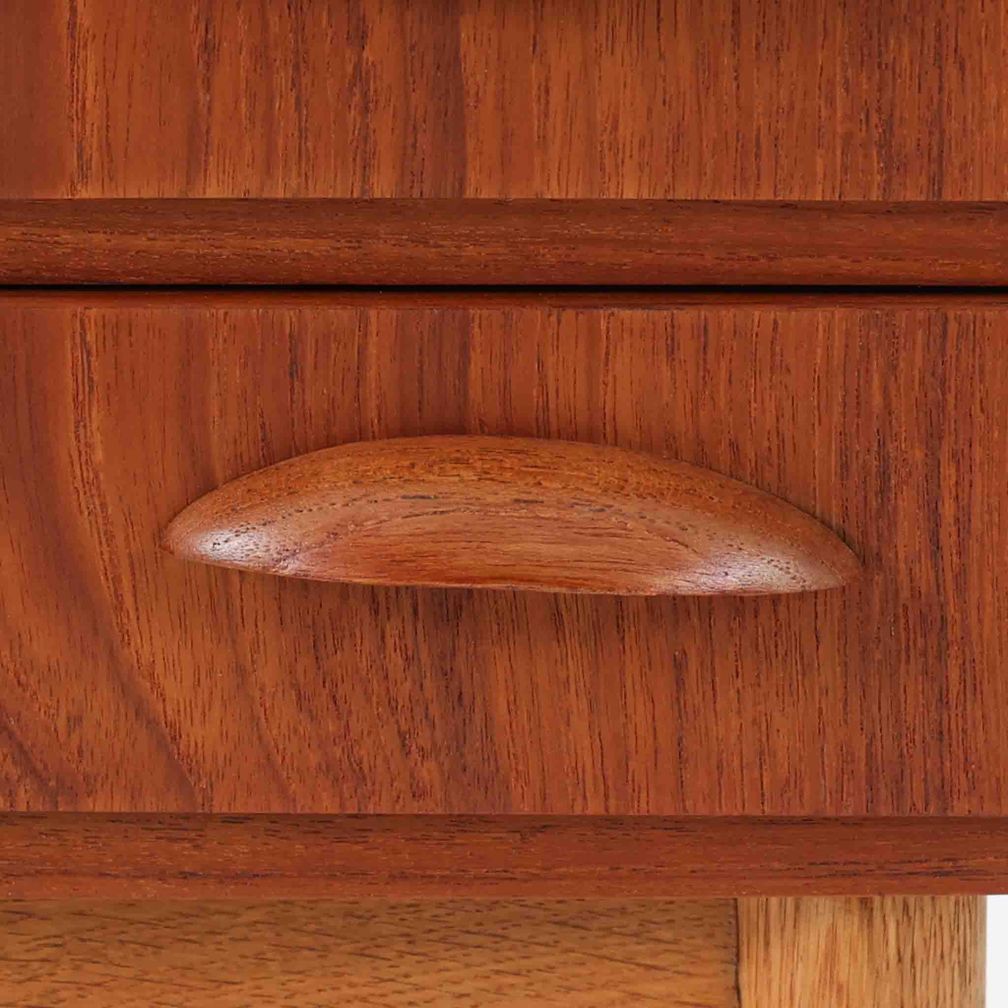 チーク材とオーク材を組み合わせた4段チェストです。前板には美しい木目を持つチーク材、脚部には明るく堅牢なオーク材が用いられ、素材のコントラストが北欧らしい洗練された印象を与えます。緩やかな曲線を描く取手や、すっきりとしたプロポーションが全体を端正にまとめ、コンパクトな幅59cmながら十分な収納力を備えています。リビングや寝室、書斎などさまざまな空間に取り入れやすく、ビンテージならではの風合いと実用性を兼ね備えた一台です。