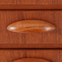 チーク材とオーク材を組み合わせた4段チェストです。前板には美しい木目を持つチーク材、脚部には明るく堅牢なオーク材が用いられ、素材のコントラストが北欧らしい洗練された印象を与えます。緩やかな曲線を描く取手や、すっきりとしたプロポーションが全体を端正にまとめ、コンパクトな幅59cmながら十分な収納力を備えています。リビングや寝室、書斎などさまざまな空間に取り入れやすく、ビンテージならではの風合いと実用性を兼ね備えた一台です。