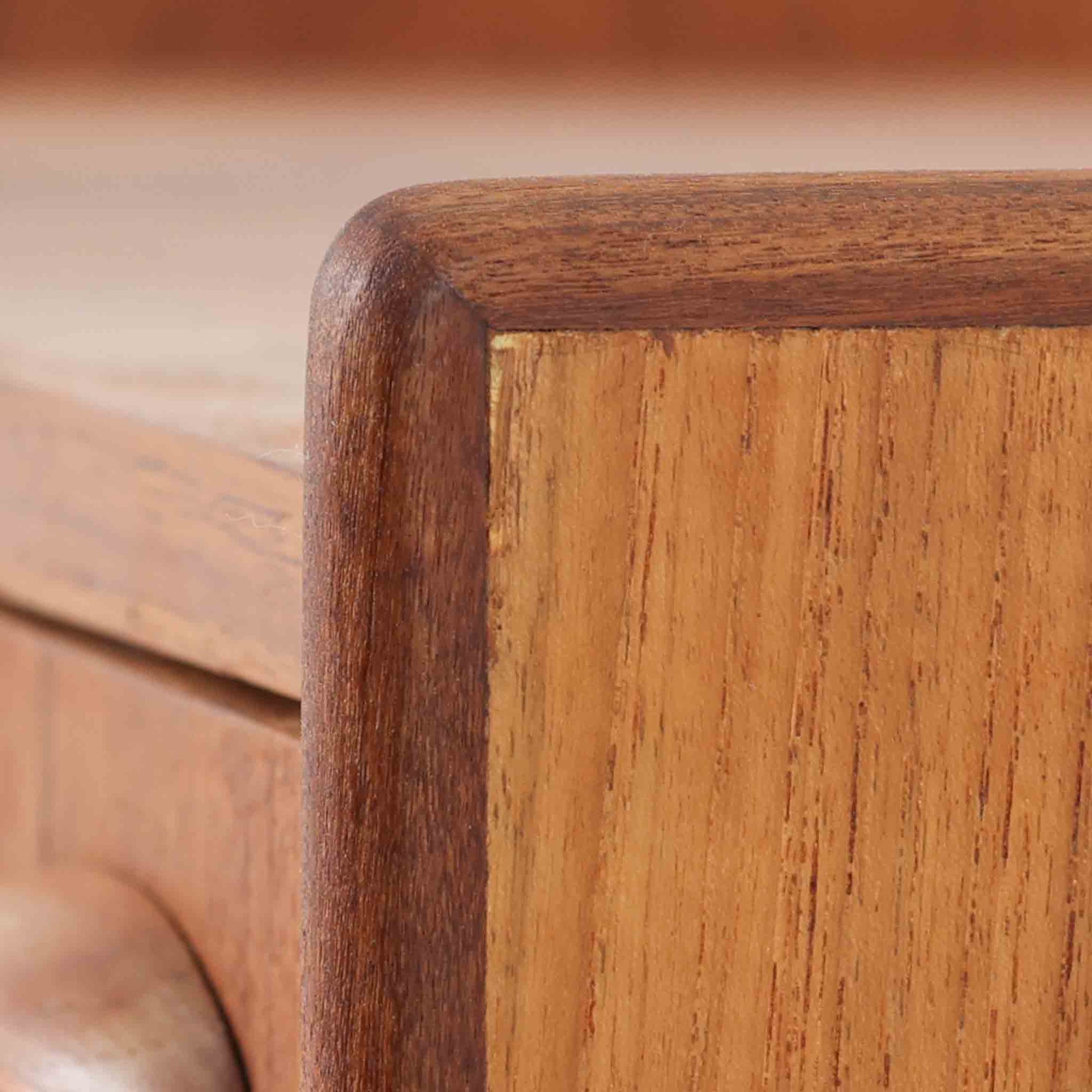 チーク材とオーク材を組み合わせた4段チェストです。前板には美しい木目を持つチーク材、脚部には明るく堅牢なオーク材が用いられ、素材のコントラストが北欧らしい洗練された印象を与えます。緩やかな曲線を描く取手や、すっきりとしたプロポーションが全体を端正にまとめ、コンパクトな幅59cmながら十分な収納力を備えています。リビングや寝室、書斎などさまざまな空間に取り入れやすく、ビンテージならではの風合いと実用性を兼ね備えた一台です。